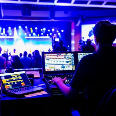 Professional technician managing lighting and sound at a live concert, showcasing modern technical skills.