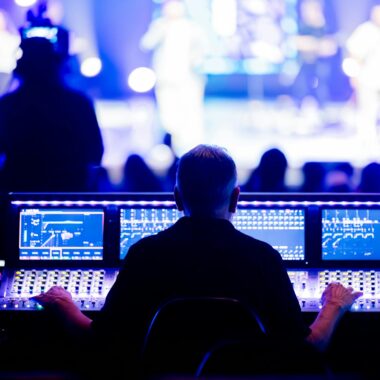 Sound engineer operating a digital mixing console during a live concert performance.